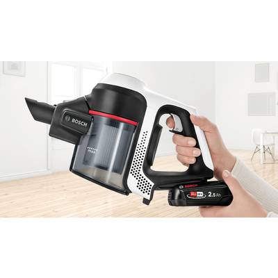 Drahtloser Handstaubsauger in einem Wohnzimmer, jemand hält ihn mit beiden Händen, zeigt Batteriewechsel-Funktion von Bosch.