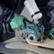 Eine Person sägt mit einer elektrischen Kreissäge Holz. Die Handschuhe sind grün, und die Säge hat eine Wasserzufuhr zur Staubunterdrückung.