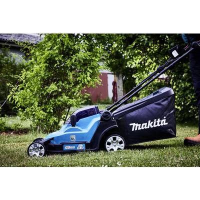 Ein blauer Rasenmäher mit 'Makita'-Logo steht auf einem grünen Rasen. Eine Person schiebt den Mäher. Im Hintergrund sind Büsche zu sehen.