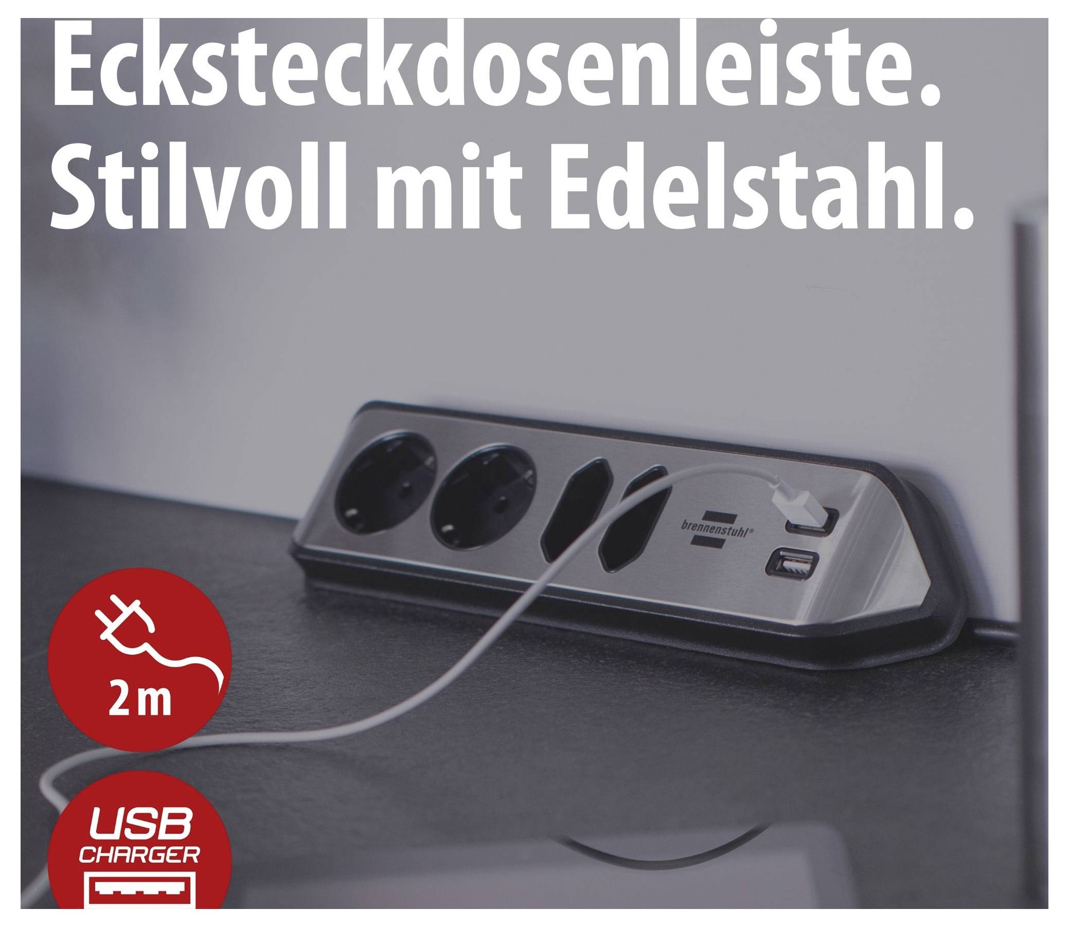 Werbeabbildung einer Steckdosenleiste mit Edelstahlgehäuse und USB-Ladeanschluss; Text: 'Ecksteckdosenleiste. Stilvoll mit Edelstahl.' sowie '2 m' und 'USB Charger'.