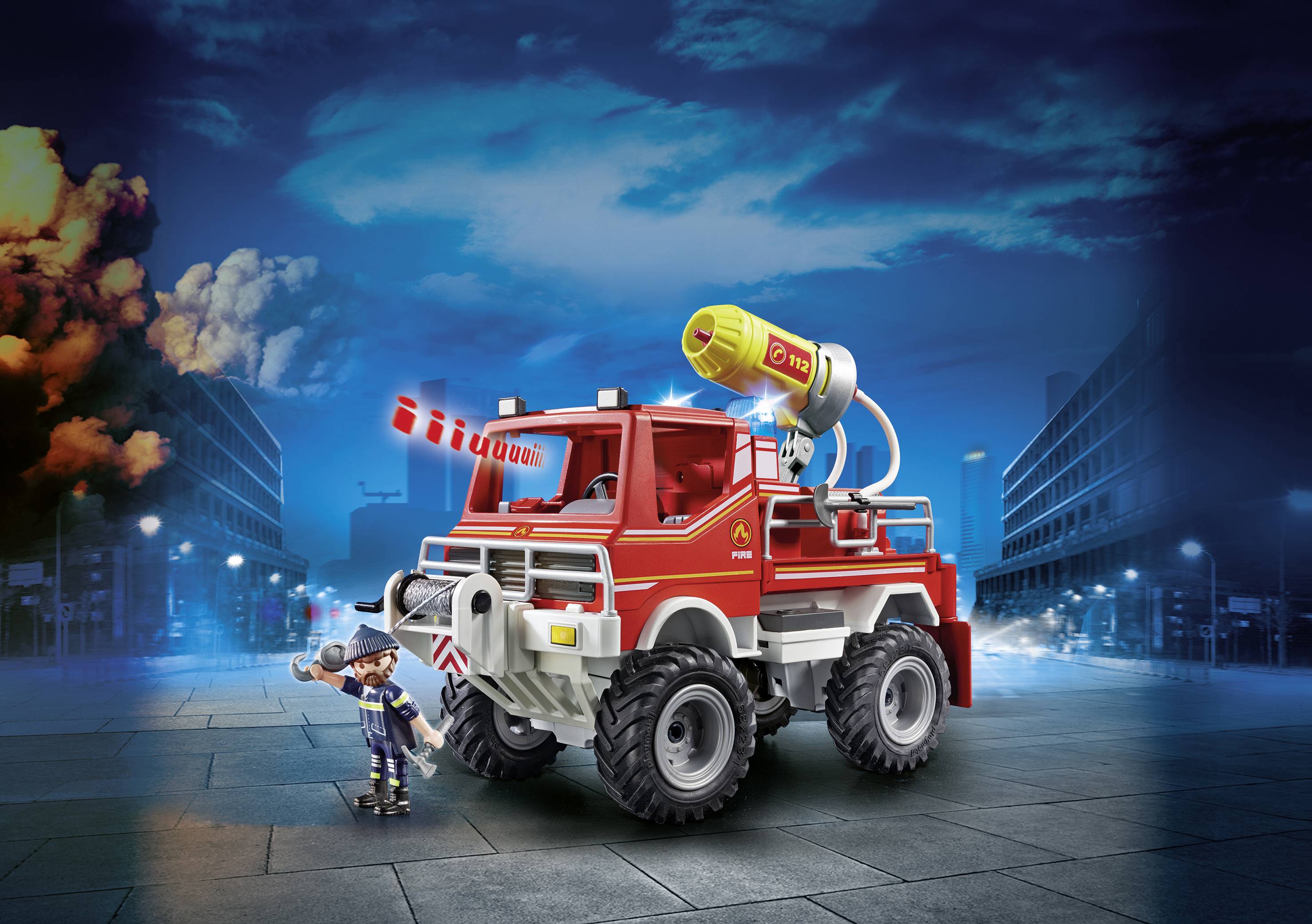 Ein Spielzeug-Feuerwehrwagen mit Wasserwerfer auf einer städtischen Straße, ein Feuerwehrmann steht daneben.