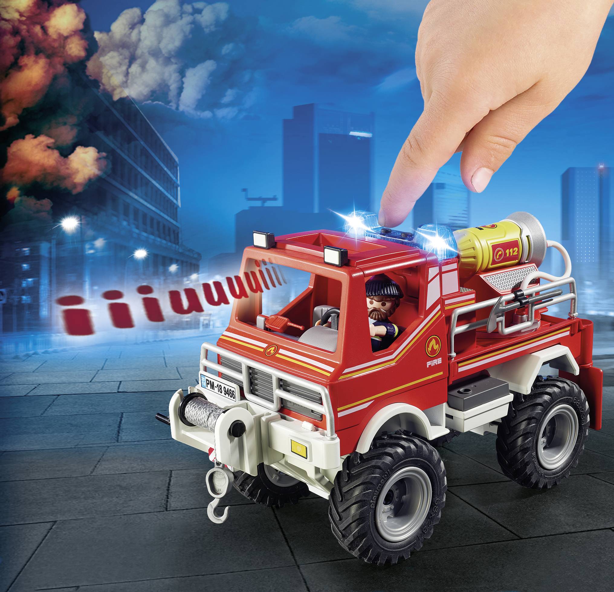 Spielzeug-Feuerwehrauto mit Feuerwehrmann auf dem Fahrersitz, daneben eine große Hand und Hintergrund mit rauchendem Gebäude.