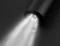 'Nahaufnahme einer Taschenlampe, die einen hellen Lichtstrahl auf eine dunkle Oberfläche wirft.'