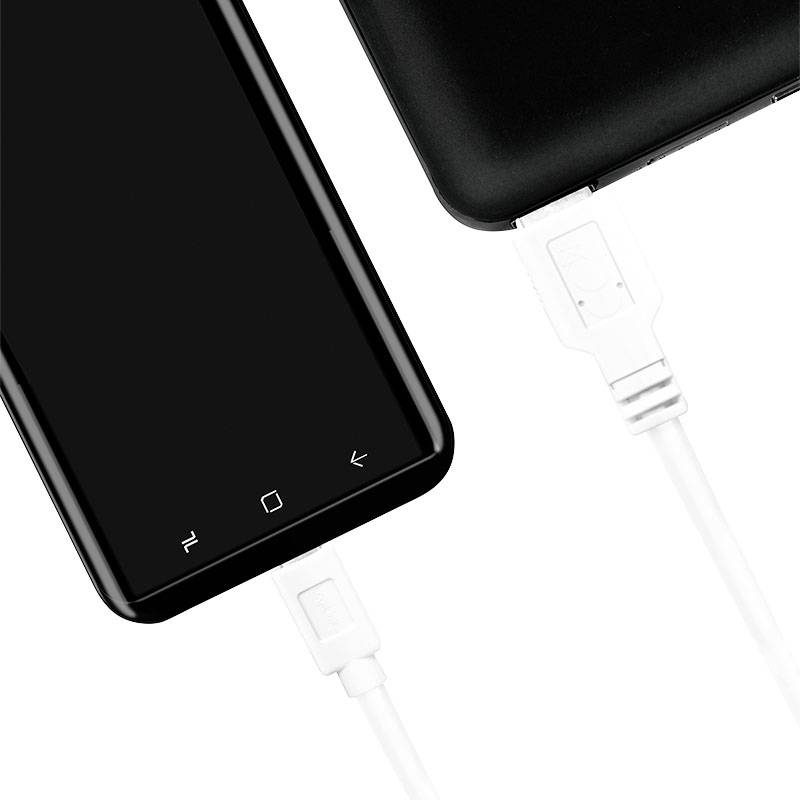 Ein Smartphone wird über ein USB-Kabel mit einem anderen Gerät verbunden, was auf einen Ladevorgang oder Datentransfer hinweist.