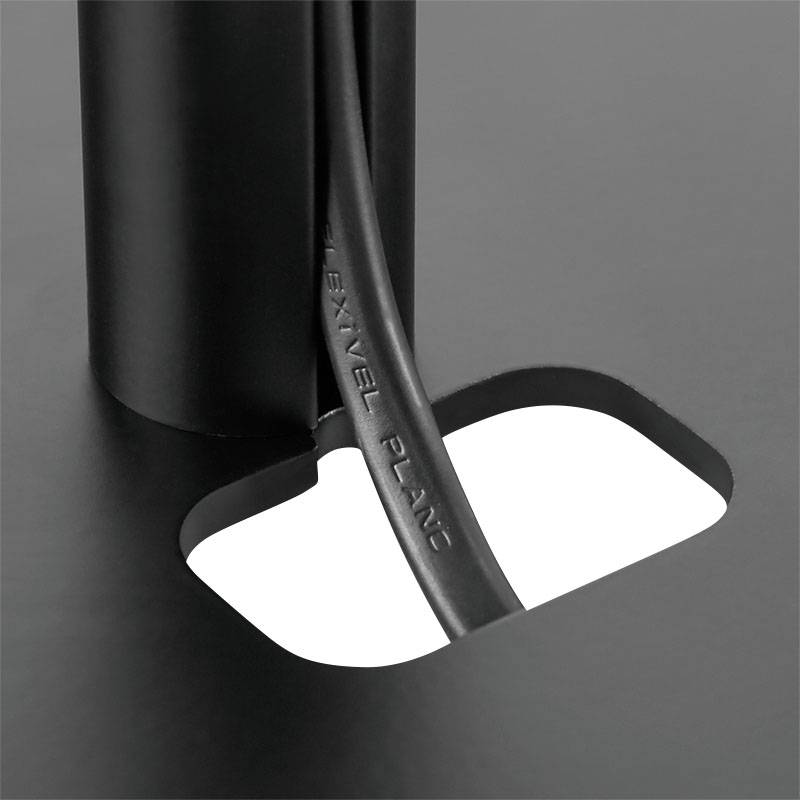Ein schwarzes Kabel mit der Aufschrift 'FLEXIBLE PLANE' geht durch ein rundes Loch in einer schwarzen Oberfläche.