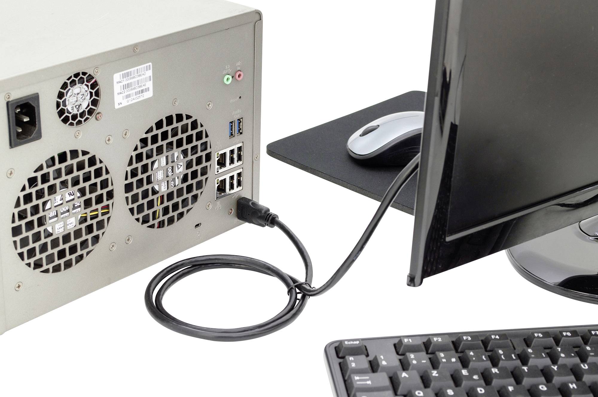 'Computer-System mit Monitor, Tastatur und angeschlossenem PC. USB-Steckplätze, Lüfter und Kabel an der Rückseite des PCs sichtbar.'