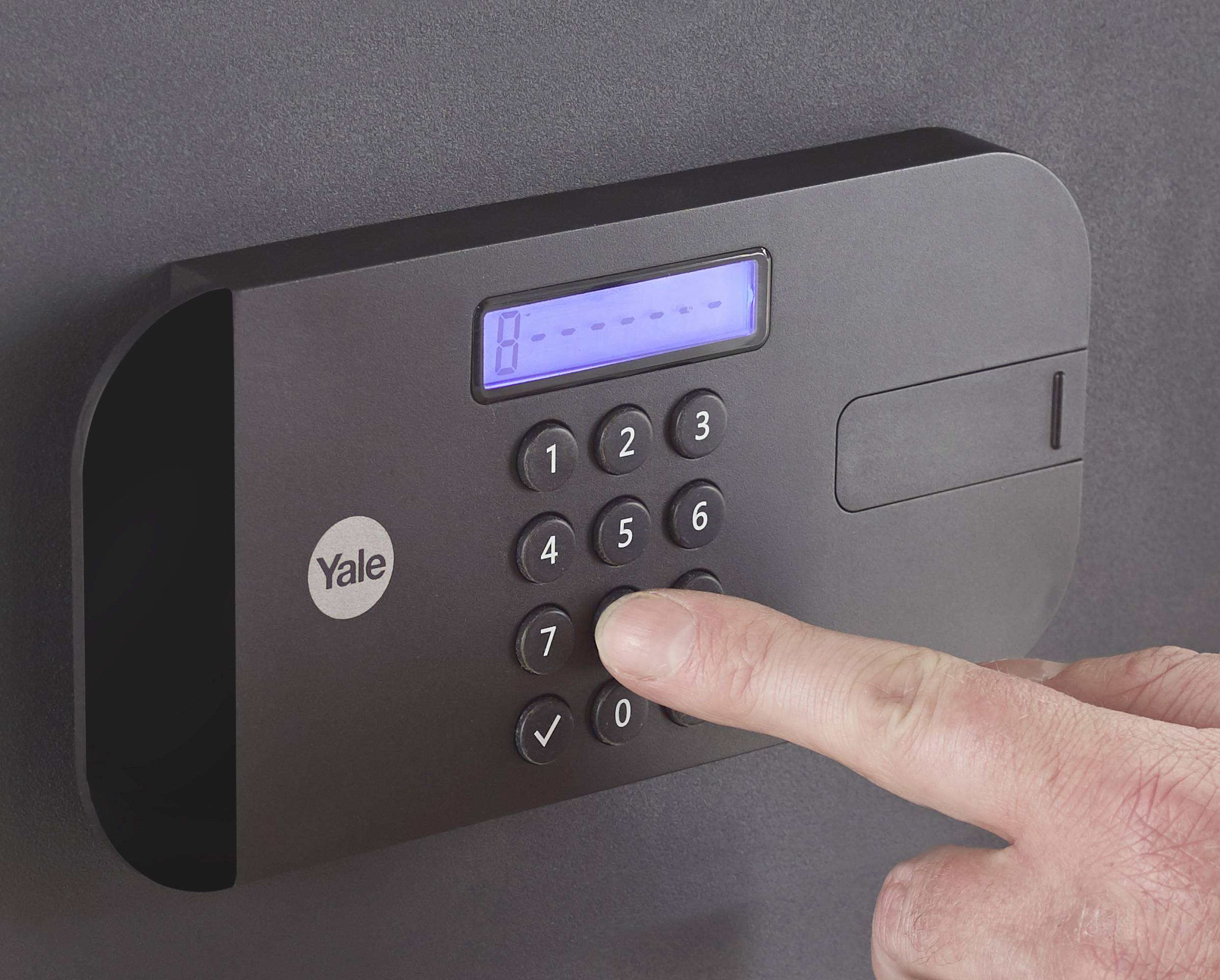 Eine Person drückt eine Taste auf einem elektronischen Zahlenschloss, das eine beleuchtete Anzeige und eine Markenkennzeichnung hat.