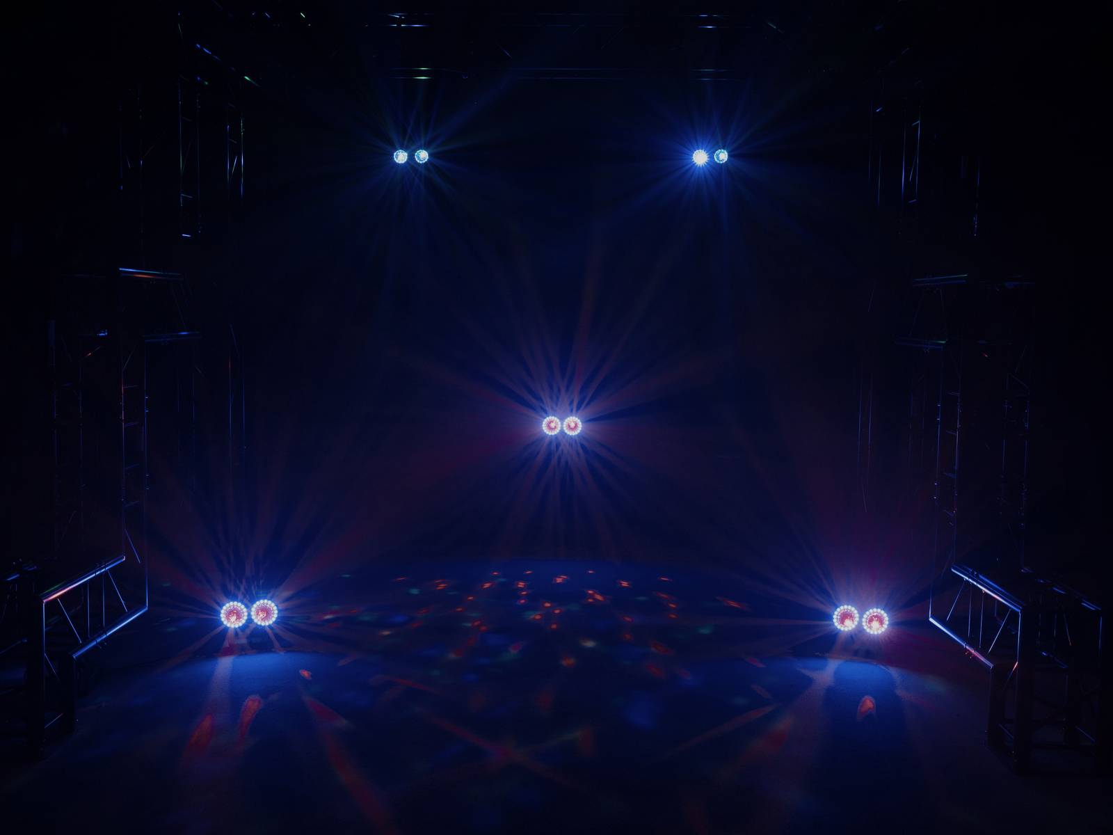 Fünf bunte Scheinwerfer beleuchten eine dunkle Bühne. Lichtstrahlen strahlen in verschiedenen Richtungen und schaffen ein Muster.