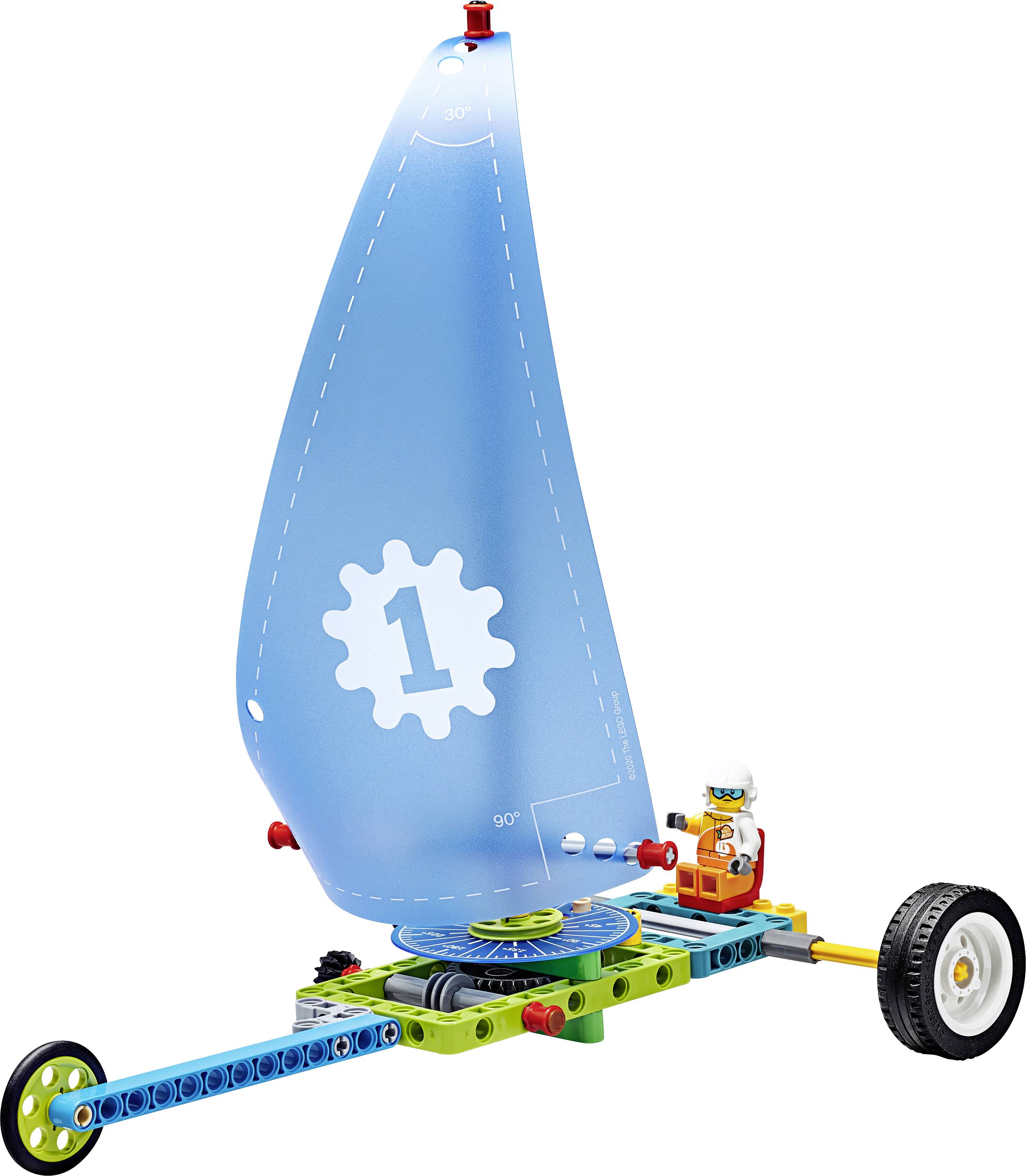 Lego-Set mit einem kleinen Segelfahrzeug, blauem Segel mit Zahnradmotiv, einem Rad vorn, zwei hinten, und einer Lego-Figur am Steuerrad.
