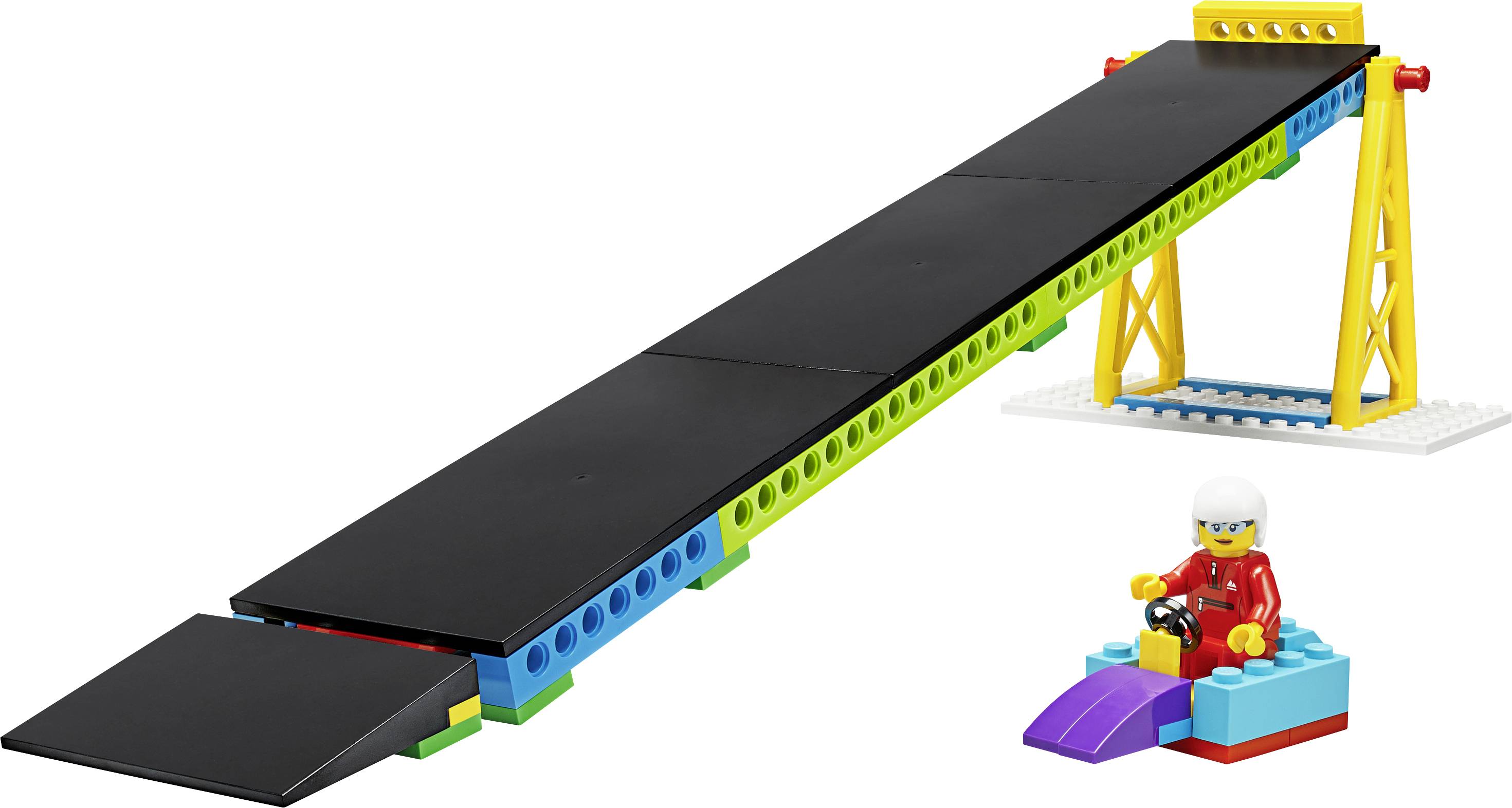 Spielzeug-Rampe aus Bausteinen mit einer Figur im Kart auf einer lila Unterlage. Die Rampe ist schwarz mit bunten Stützen.