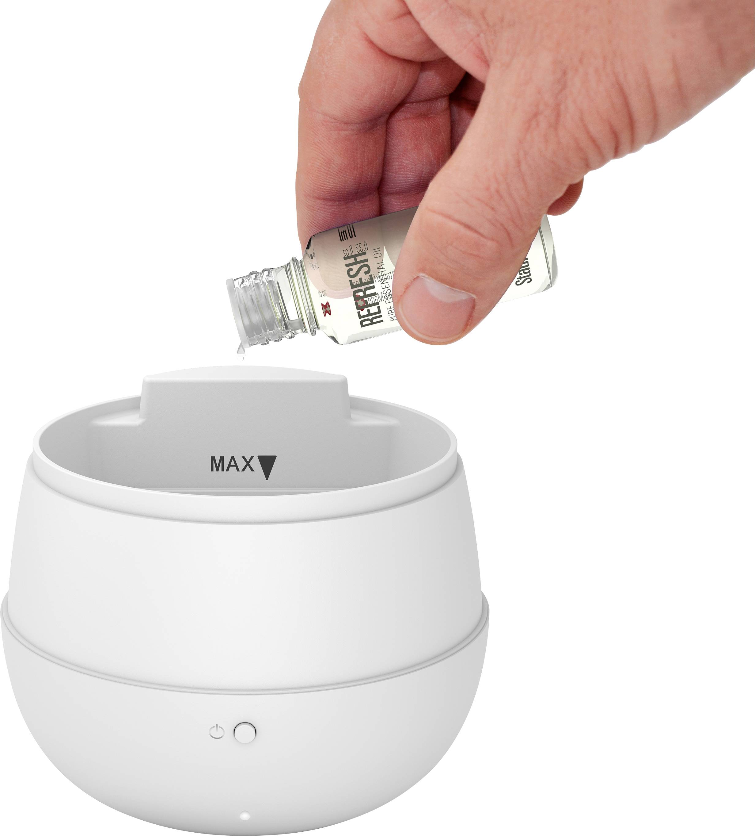 Eine Hand gießt ätherisches Öl in einen weißen Aroma-Diffusor bis zur "MAX"-Markierung.
