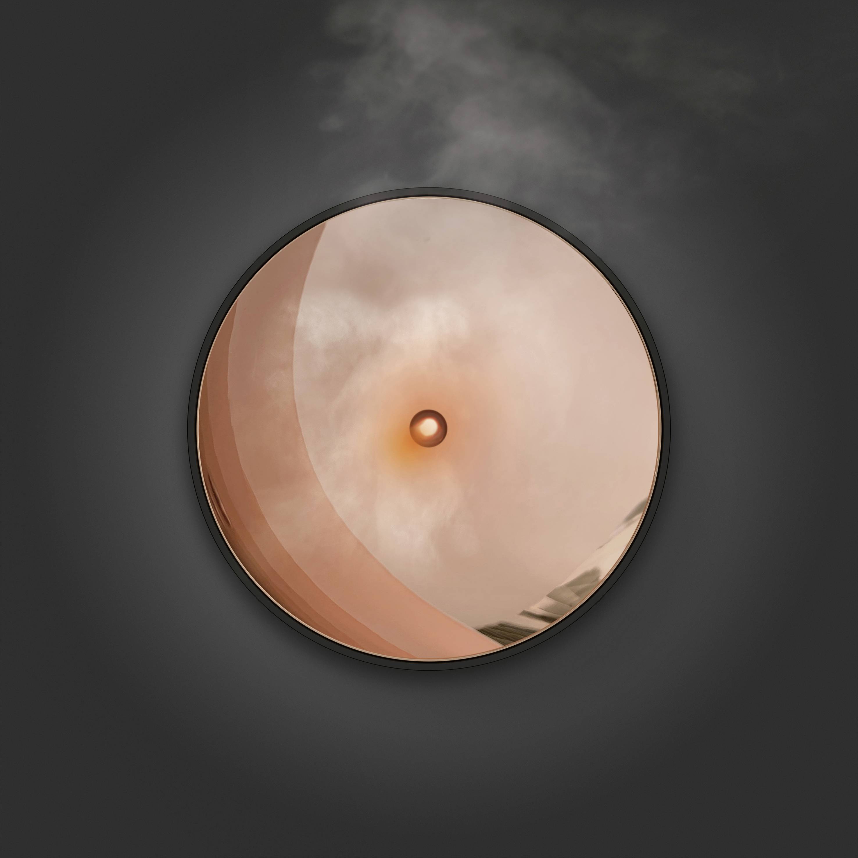 Ein runder, orangefarbener Knopf oder Schalter auf einer dunklen Oberfläche, leicht rauchig oder neblig umgeben.