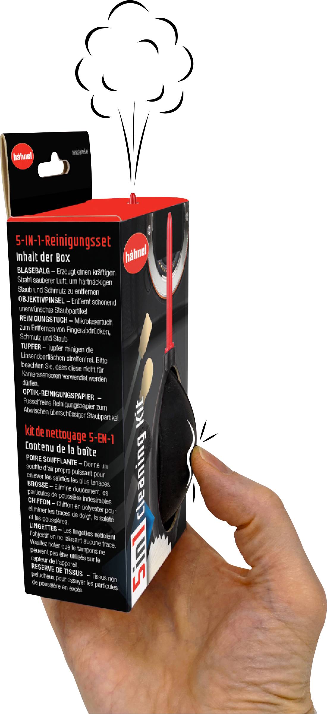 Eine Hand hält eine Schachtel eines 5-in-1-Reinigungssets mit einer Puste, Pinsel und Text in mehreren Sprachen.