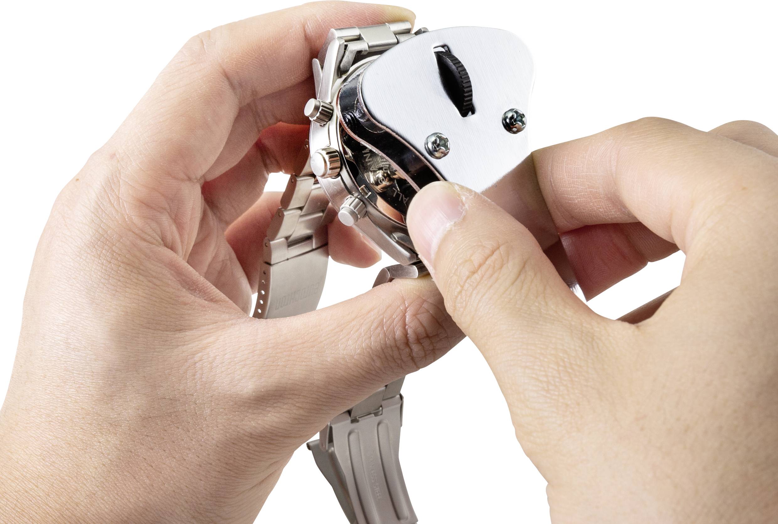 Zwei Hände öffnen das Gehäuse einer Armbanduhr mit einem speziellen Werkzeug, um an das Innenleben oder die Batterie zu gelangen.
