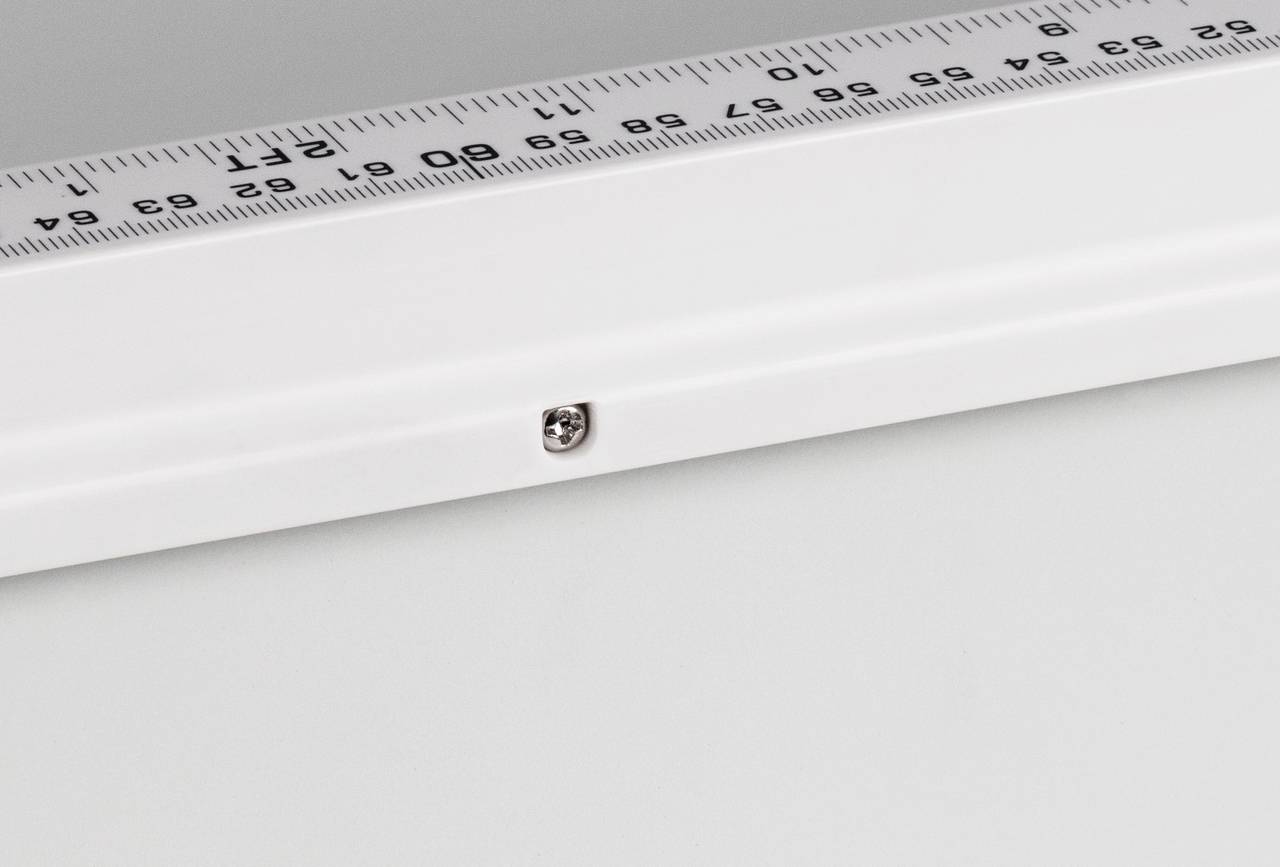 Ein weißes Lineal auf einem Tisch zeigt Zentimeter und Millimeter. Eine kleine Schraube ist auf dem Montagerand sichtbar.