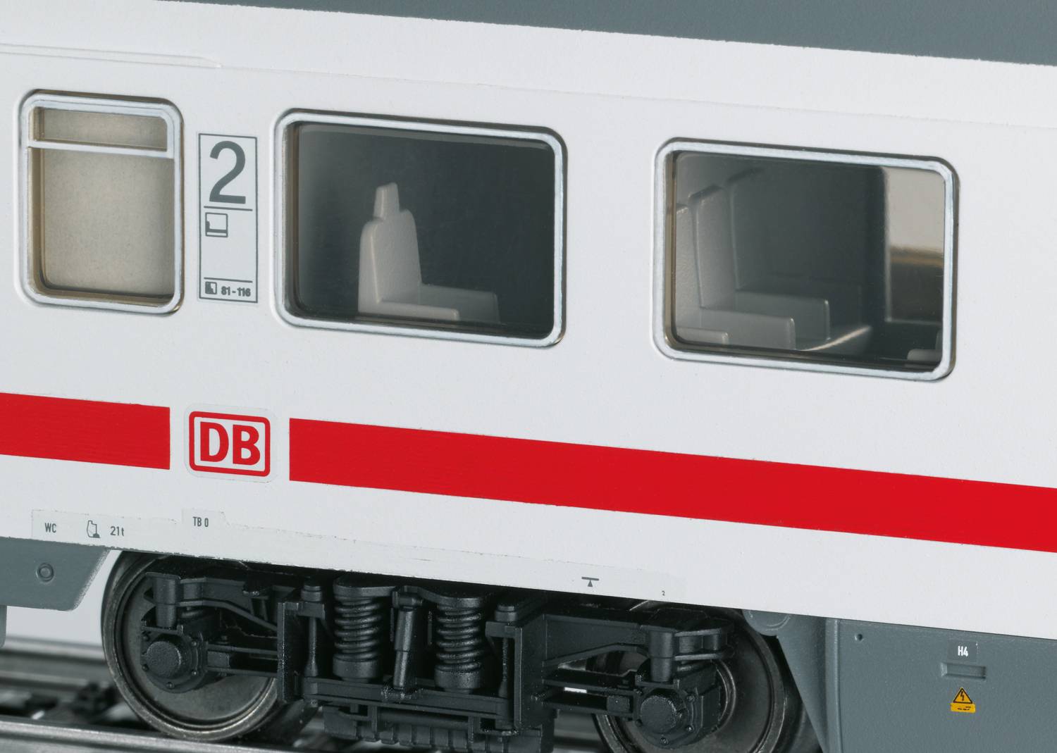 Ein ICE-Wagen der Deutschen Bahn in Nahaufnahme, erkennbar an der roten Linie und dem 'DB'-Logo auf weißem Hintergrund.
