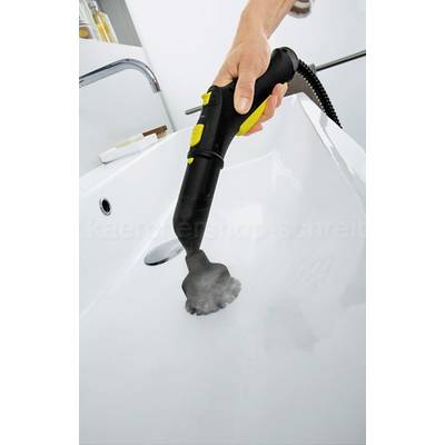 Eine Hand hält einen Dampfreiniger mit gelber und schwarzer Düse über einem weißen Waschbecken, das von Dampf gereinigt wird.