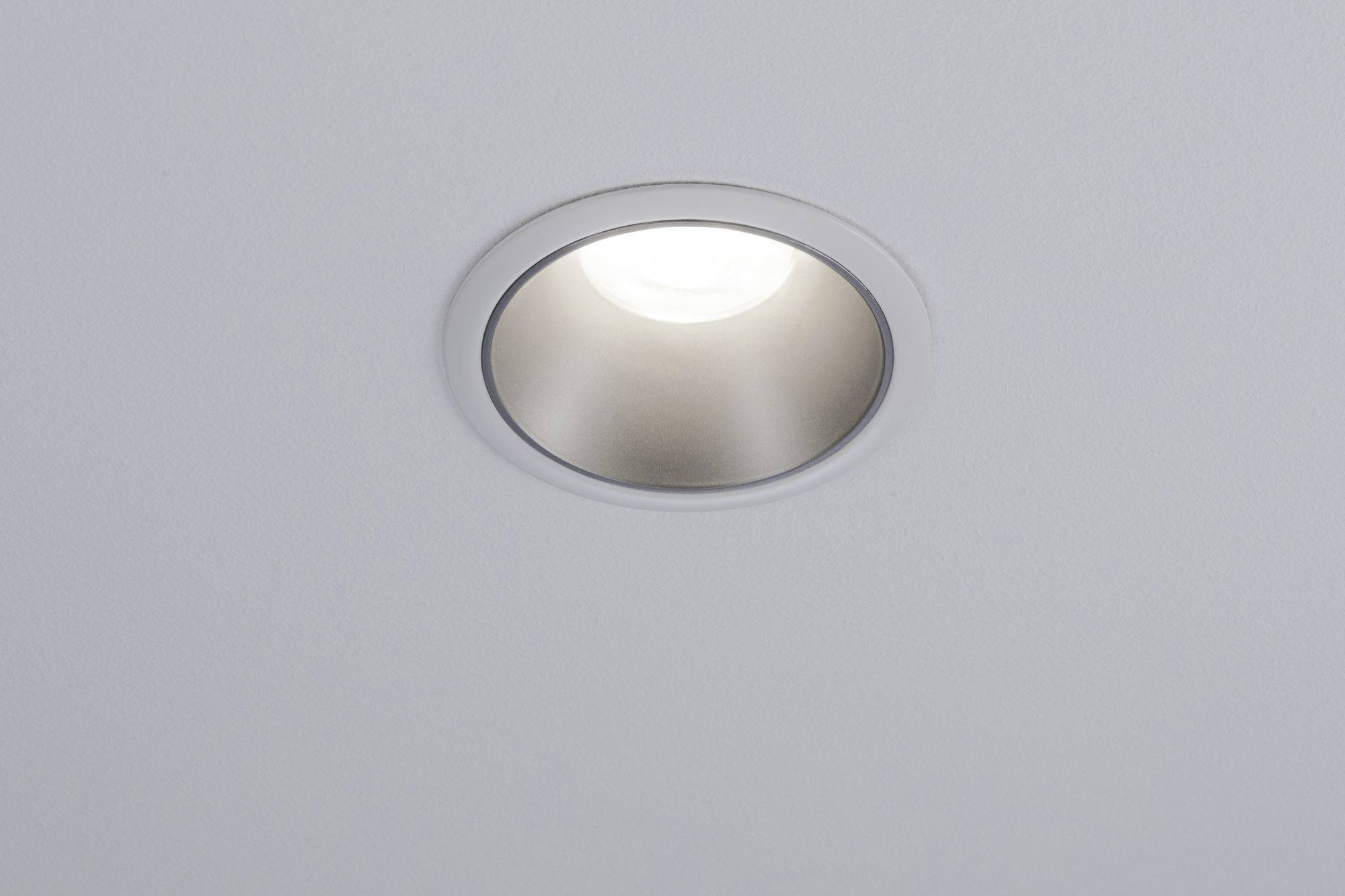 Eine runde, in die Decke eingelassene LED-Leuchte, die nach unten strahlt und eine gleichmäßige Beleuchtung bietet.