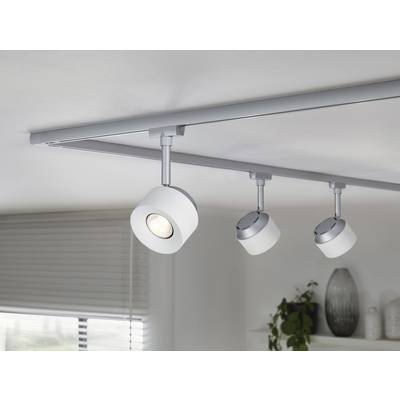 Drei moderne, einzeln einstellbare Deckenstrahler an einer silbernen Schiene beleuchten einen Raum mit Pflanzen und einem Fenster.