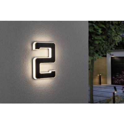 Leuchtende Hausnummer '2' an einer grauen Wand, umgeben von einem modernen Garten mit Bäumen und gepflastertem Gehweg.