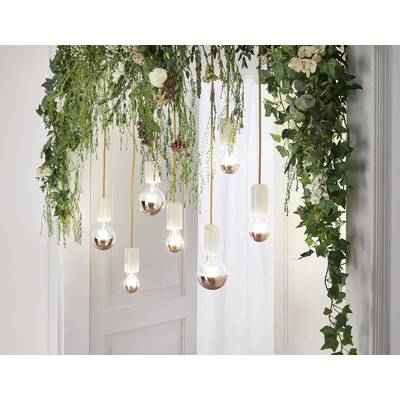 Hängende Glühbirnen mit Kupferunterteil von üppigem Grün und Blumen umgeben, vor einer weißen Wand.