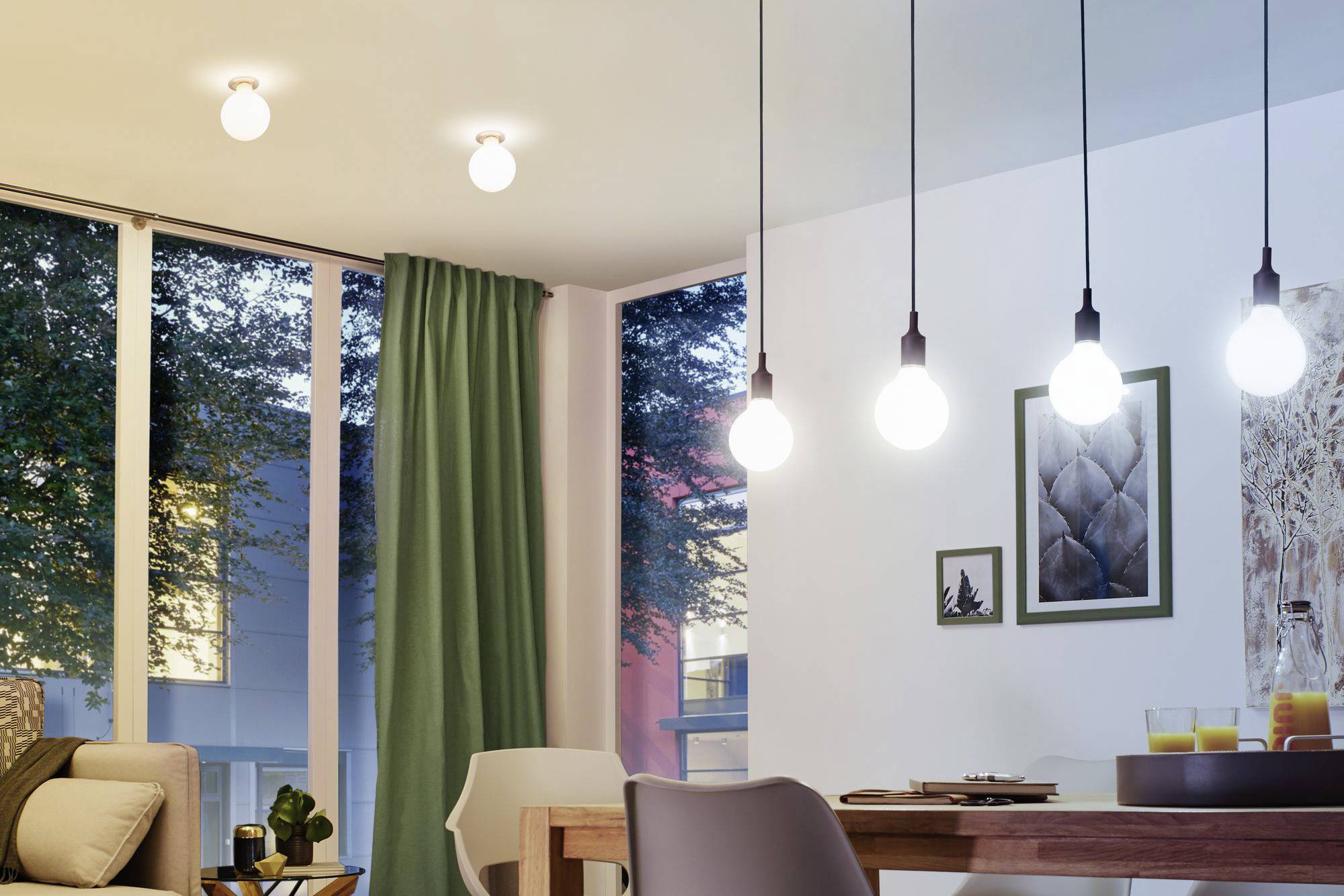 Helles Wohnzimmer mit modernen Hängelampen, Glasschiebetüren und grünen Vorhängen. Im Hintergrund sind Bäume sichtbar.