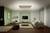 Modernes Wohnzimmer mit grün-weißer Wandgestaltung, einem Sofa, Couchtisch, Sessel, Teppichen, Regal und Flachbildfernseher.