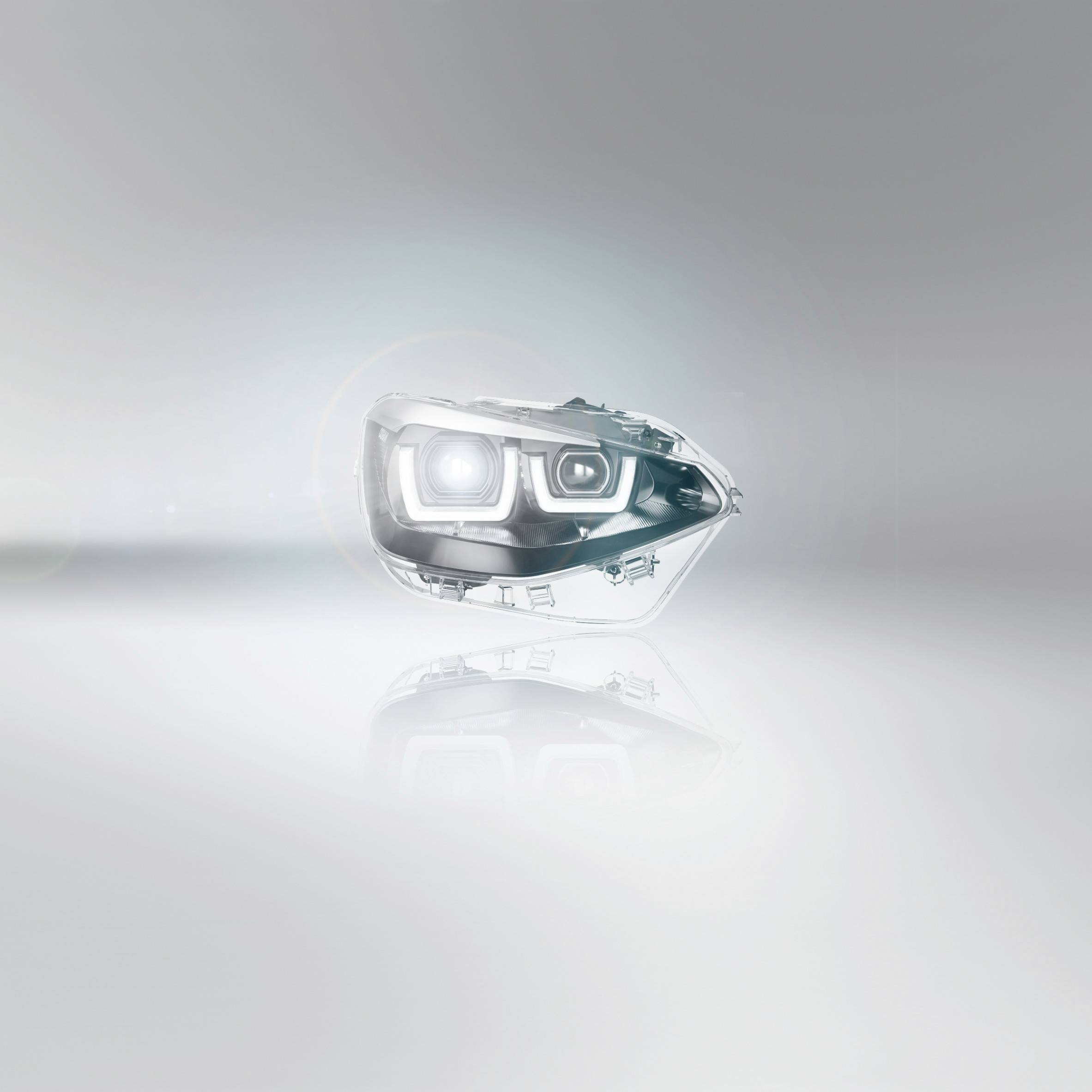 Ein einzelner Scheinwerfer in modernem, dynamischem Design schwebt vor einem hellgrauen Hintergrund und symbolisiert innovative Beleuchtungstechnologie.