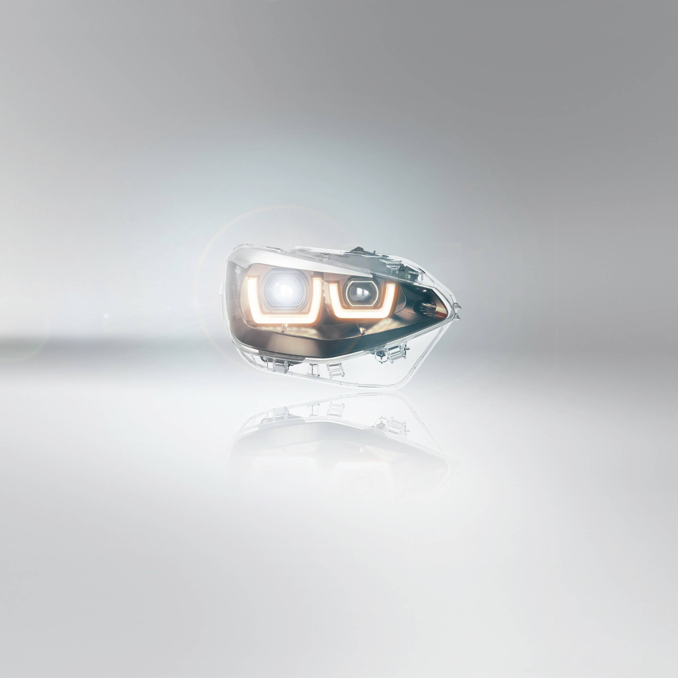 Scheinwerfer eines Autos mit leuchtendem LED-Licht auf hellem Hintergrund, zeigt modernes Autodesign.