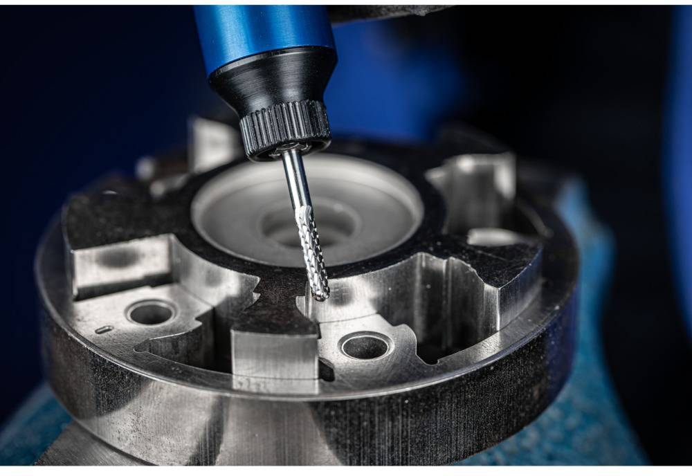 Nahaufnahme eines Fräsers, der ein Metallteil bearbeitet, zeigt präzise Verarbeitungstechnik und Detailgenauigkeit in der Metallbearbeitung.