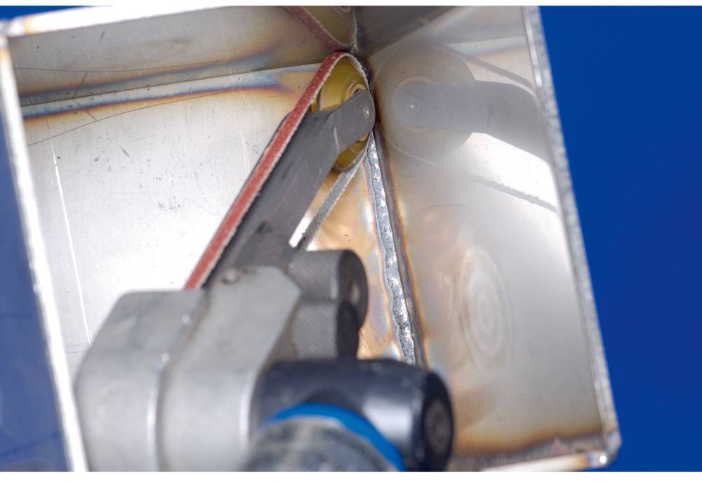 Nahaufnahme eines Winkels aus Metall, auf dem Schweißenähte sichtbar sind. Eine Metallstange ist in den Winkel integriert.