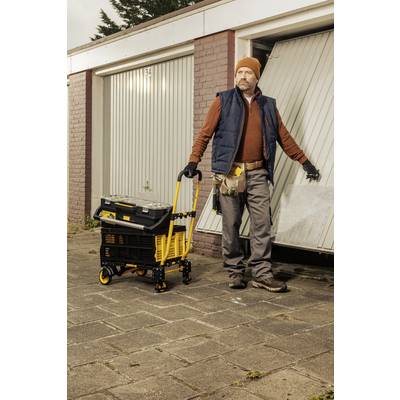 Eine Person in Arbeitskleidung öffnet ein Garagentor und hält einen gelben Werkzeugwagen. Die Szene wirkt arbeitsorientiert und praktisch.