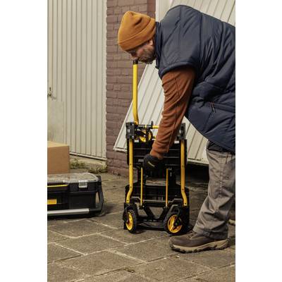 Mann zieht einen Handwagen mit gelben Rädern vor einer Garage. Daneben steht ein Werkzeugkasten. Er trägt eine orangefarbene Mütze und Handschuhe.