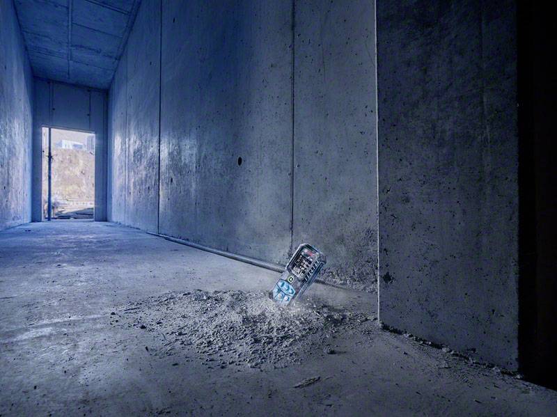 Eine leere Getränkedose lehnt an der Betonwand eines langen, dunklen Gangs. Am Ende des Gangs ist ein offener Türrahmen zu sehen.