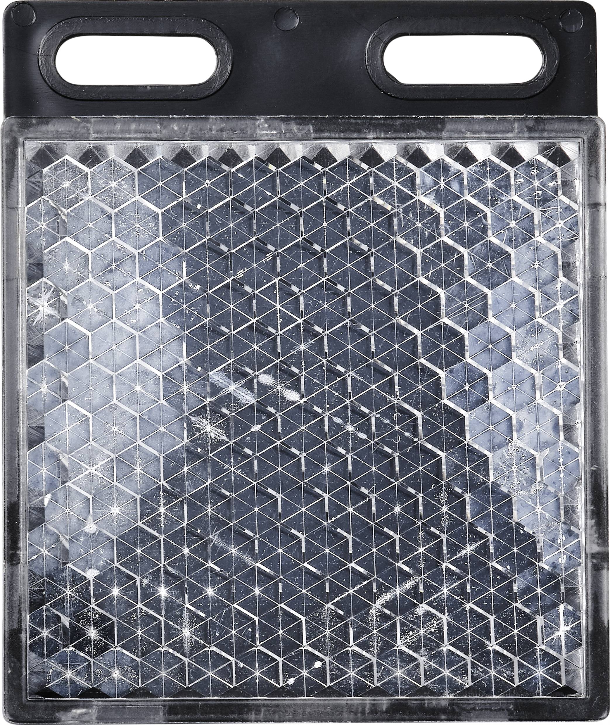 Ein rechteckiges, dunkles Brett mit geometrischem Hexagon-Muster und zwei Griffen oben.