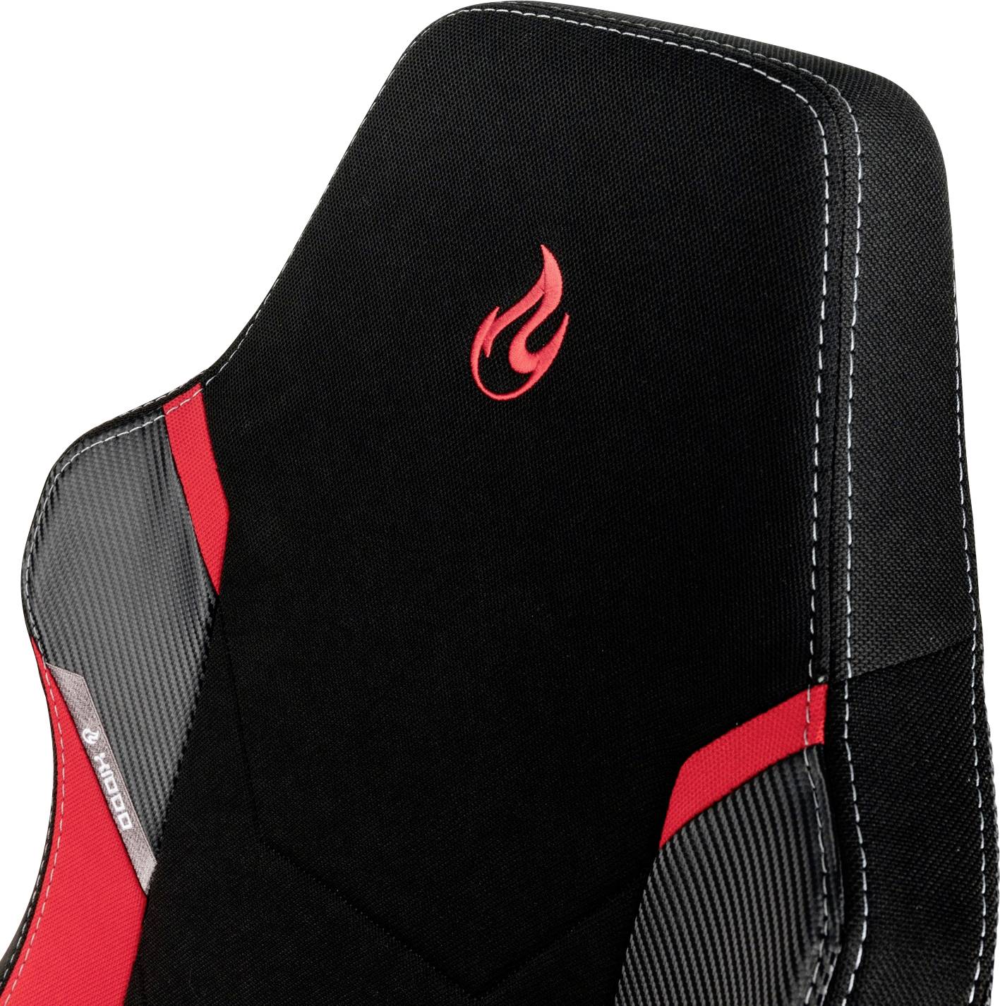 Ein Gaming-Stuhl mit schwarzem Stoff und roten Einsätzen. Oben auf der Rückenlehne befindet sich ein rotes Flammenlogo.