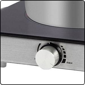 Nahaufnahme eines silbernen Drehknopfes an einem Küchenherd, der auf 'max' gedreht ist. Der Hintergrund zeigt einen Teil des Herdes.