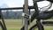 Fahrrad mit schwarzem Rahmen steht gesichert an einem grauen Pfosten mit einem robusten Bügelschloss, Landschaft im Hintergrund.