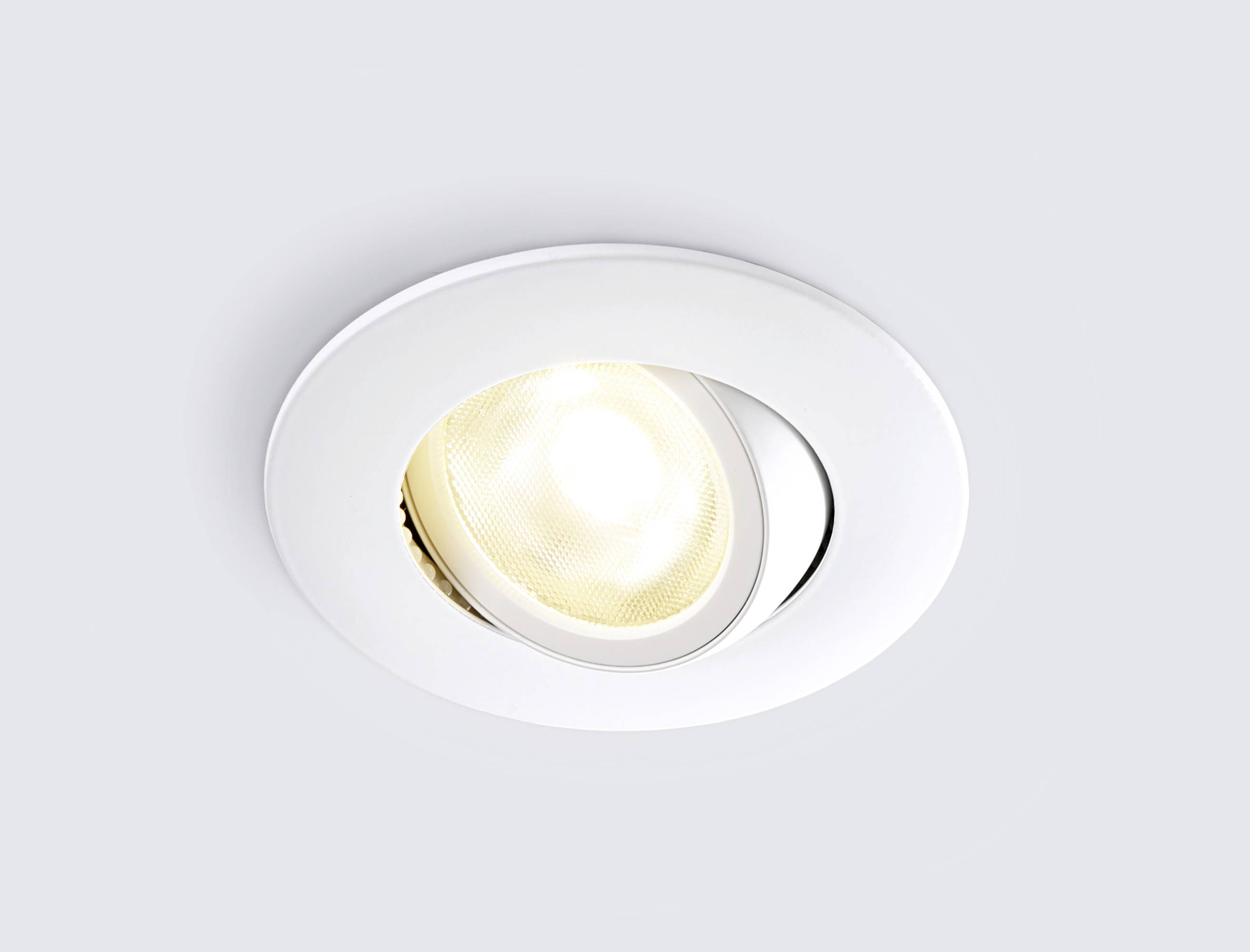 Einbau-Spotlicht in der Decke mit leuchtender LED-Lampe, kreisförmiger weißer Rahmen.