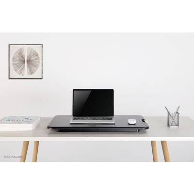 Ein sauberer, moderner Schreibtisch mit einem Laptop auf einem Schwarz-Schreibtischaufsatz, rechts eine Maus, links Bücher. Rechts ein Stiftehalter. Im Hintergrund Kunst an der Wand.