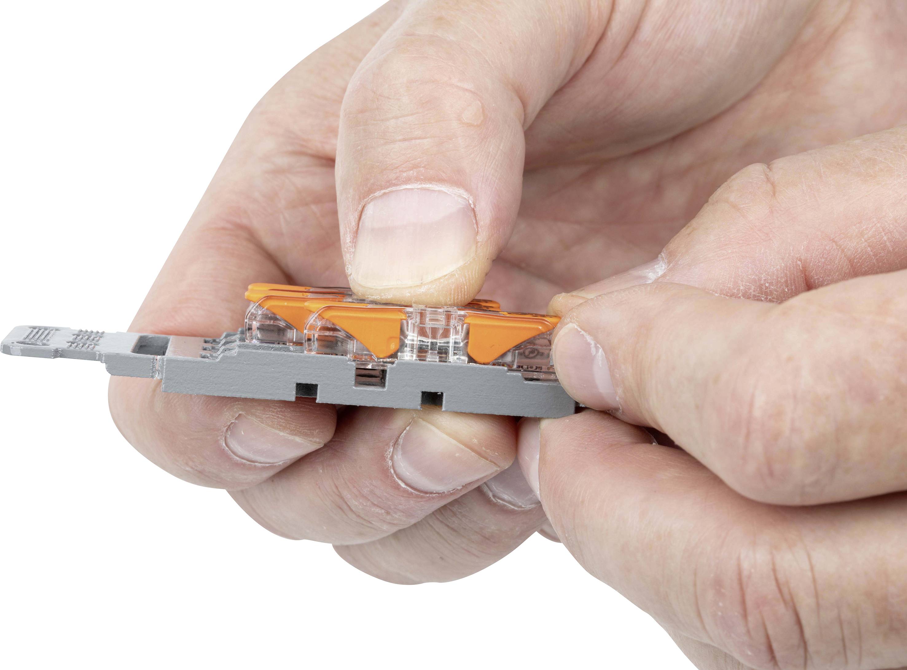 'Zwei Hände halten eine graue Steckklemme mit orangefarbenen Hebeln.'