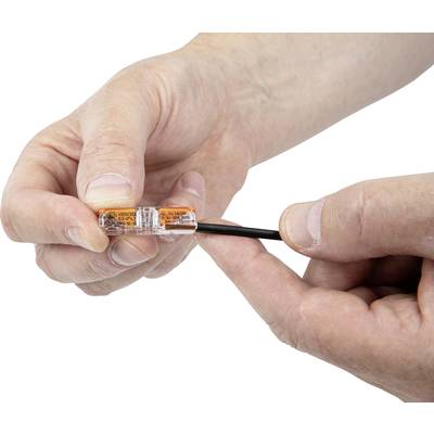 Hände verbinden ein schwarzes Kabel mit einem durchsichtigen Kunststoffstecker.