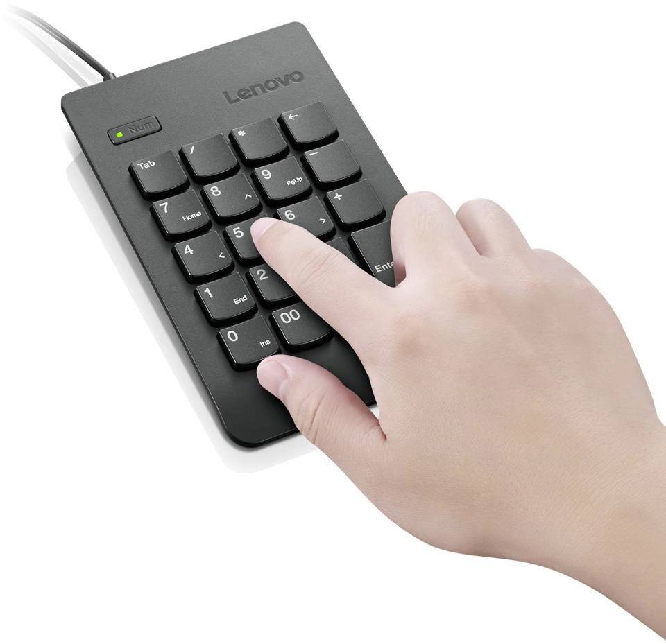 Eine Hand tippt auf ein externes numerisches Tastenfeld mit Kabel, das neben einem Computer verwendet werden kann.