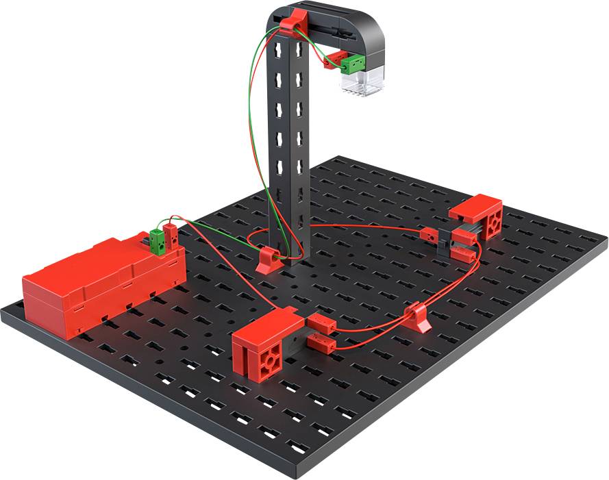 'Elektrisches Experimentierkit mit roten und grünen Kabeln auf schwarzer Lochplatte. Enthält Batteriehalter und elektrische Anschlüsse.'