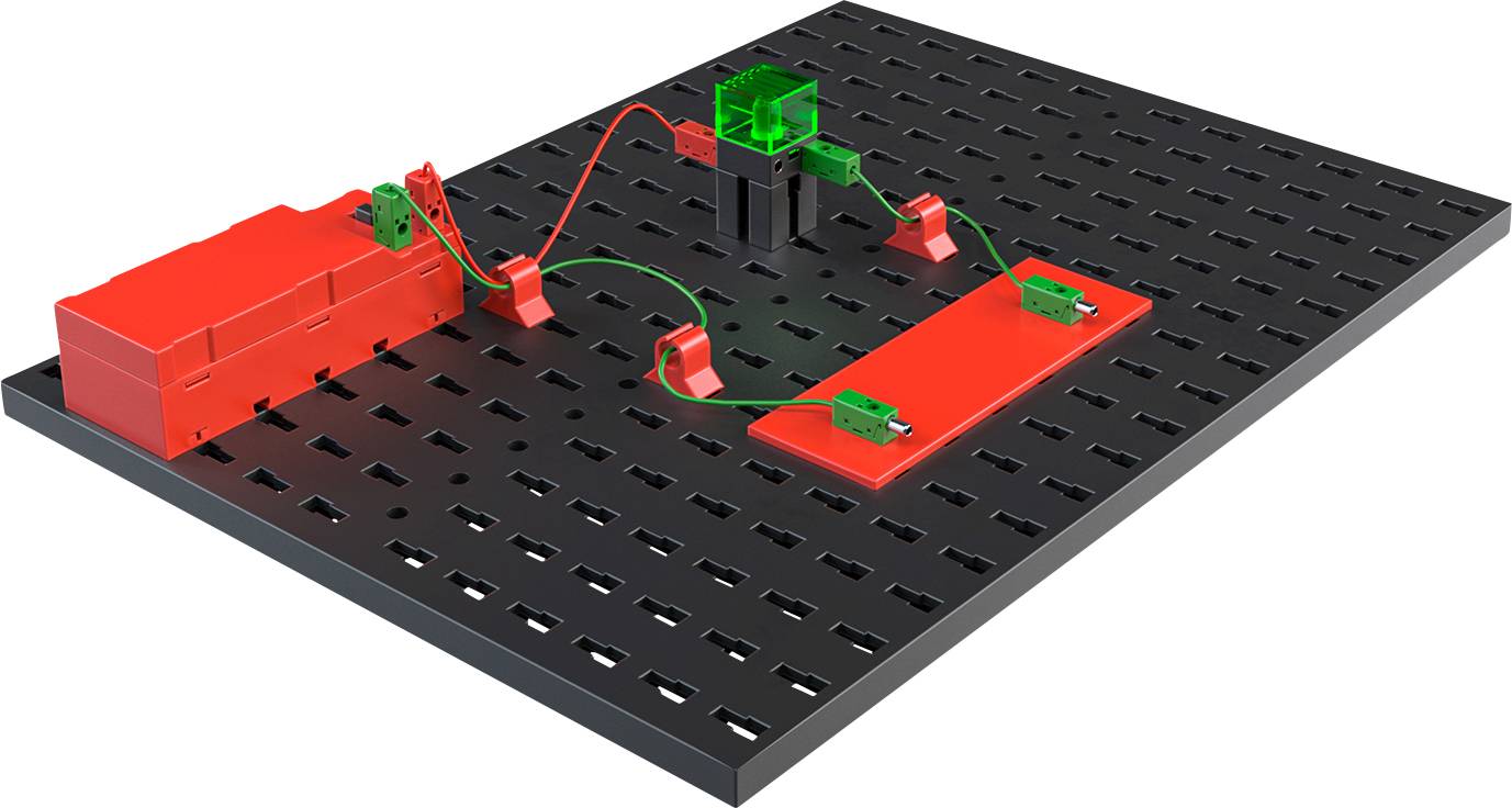 Ein Schaltkreis-Experimentierfeld mit einer Batterie, verbunden über Kabel mit einer Leuchtdiode und einem Schalter, demonstriert Stromfluss.
