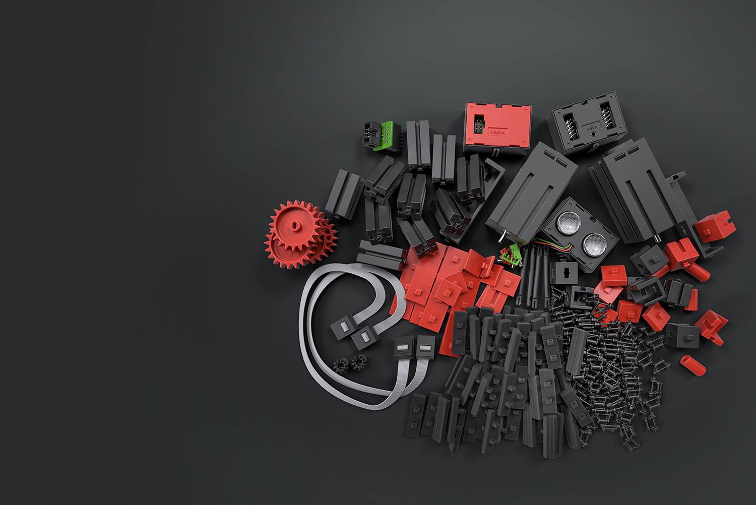 Verschiedene schwarze und rote Plastikbauteile und Zahnräder auf dunklem Hintergrund. Die Teile sind verstreut und scheinen Teil eines Baukastens zu sein.