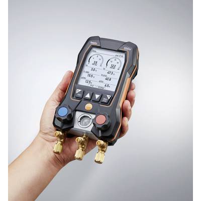 Eine Hand hält ein digitales Manometer, das Druck und Temperatur auf einem Display anzeigt. Das Gerät hat rote und blaue Ventile.