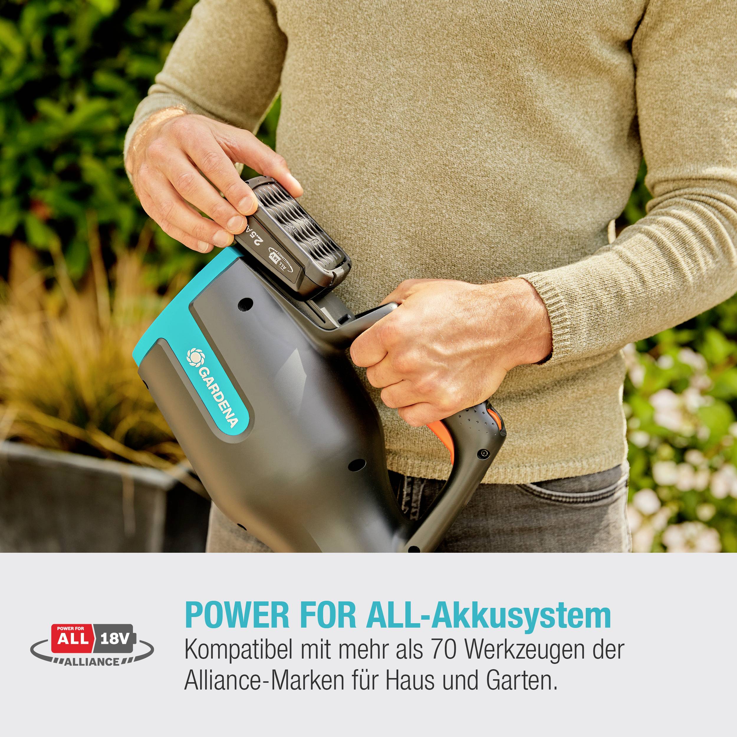 Eine Person hält einen Rasenmäher-Akku. Text: 'Power for All-Akkusystem' - Kompatibel mit über 70 Werkzeugen der Alliance-Marken.