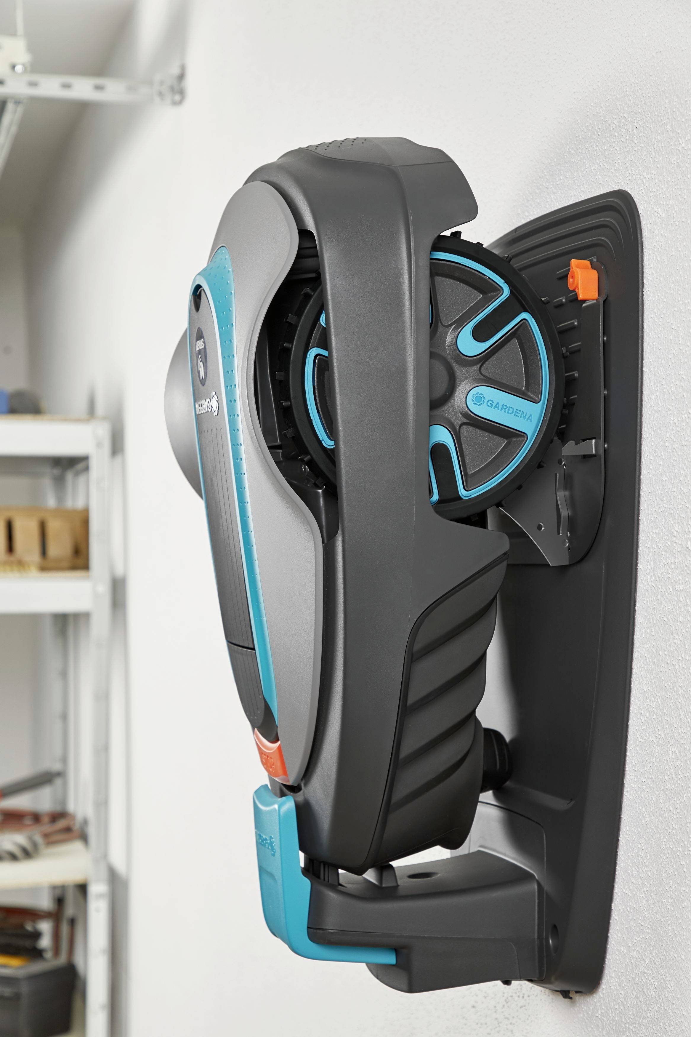 Wandhalterung mit einem modernen, ergonomisch geformten Gartengerät in Schwarz und Türkis, montiert in einem Abstellraum.