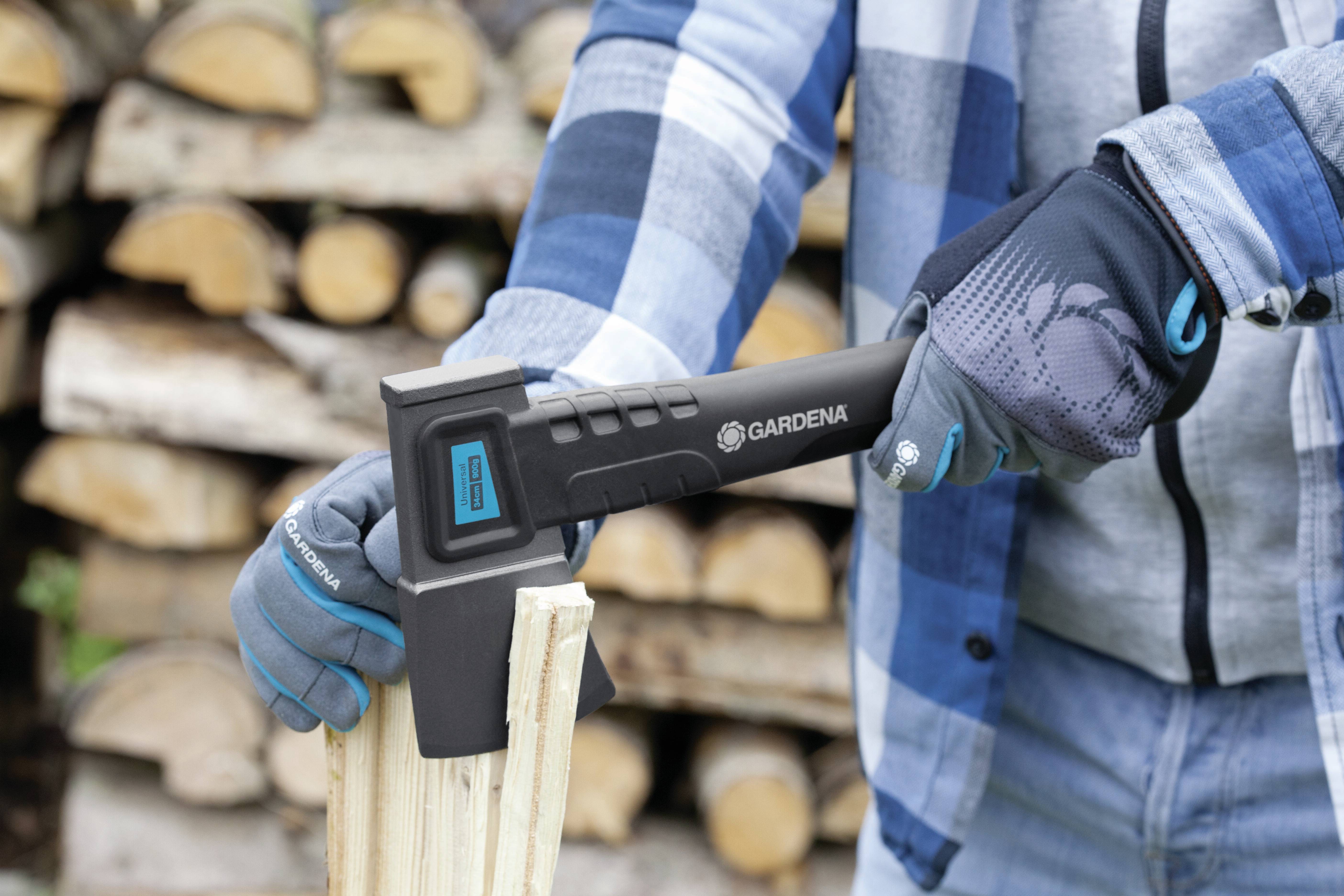 Person in kariertem Hemd, die Holz mit einer Axt spaltet; Hintergrund aus gestapeltem Holz.